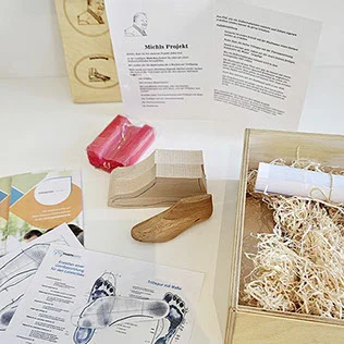 Inhalt der Michl-Box „Der Halbschuhleisten": Holzleisten, Musterleisten, rote Knetmasse, Arbeitsblätter und Holzkiste mit Holzwolle